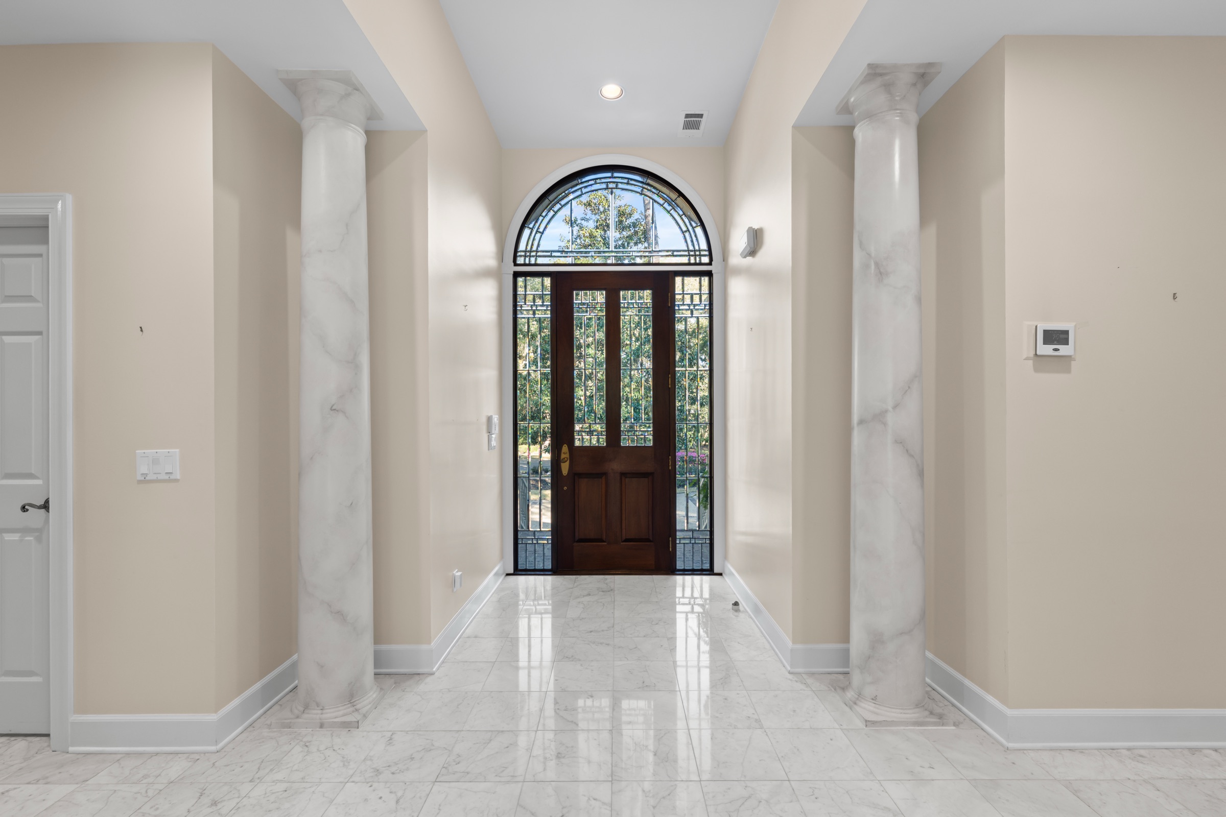 Foyer with marble floors and columns